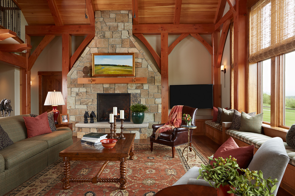 Large rustic formal open plan living room in Minneapolis with a standard fireplace, a stone fireplace surround, a wall mounted tv, beige walls, medium hardwood flooring and brown floors.