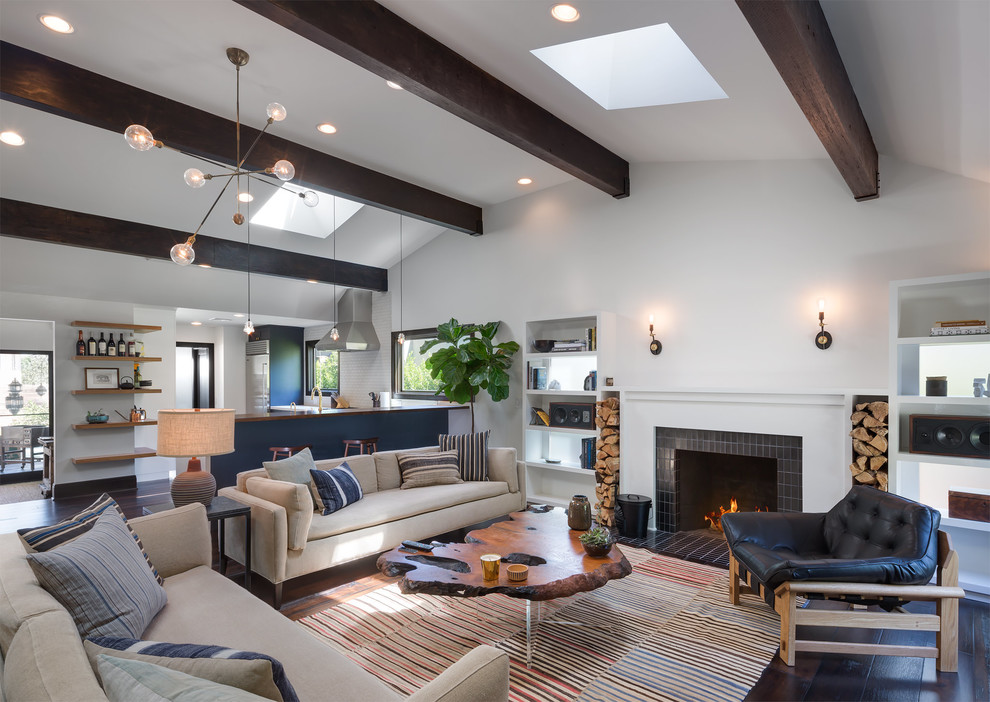 Design ideas for an expansive contemporary open plan living room in Los Angeles with white walls, dark hardwood flooring, a standard fireplace, a tiled fireplace surround, no tv and brown floors.