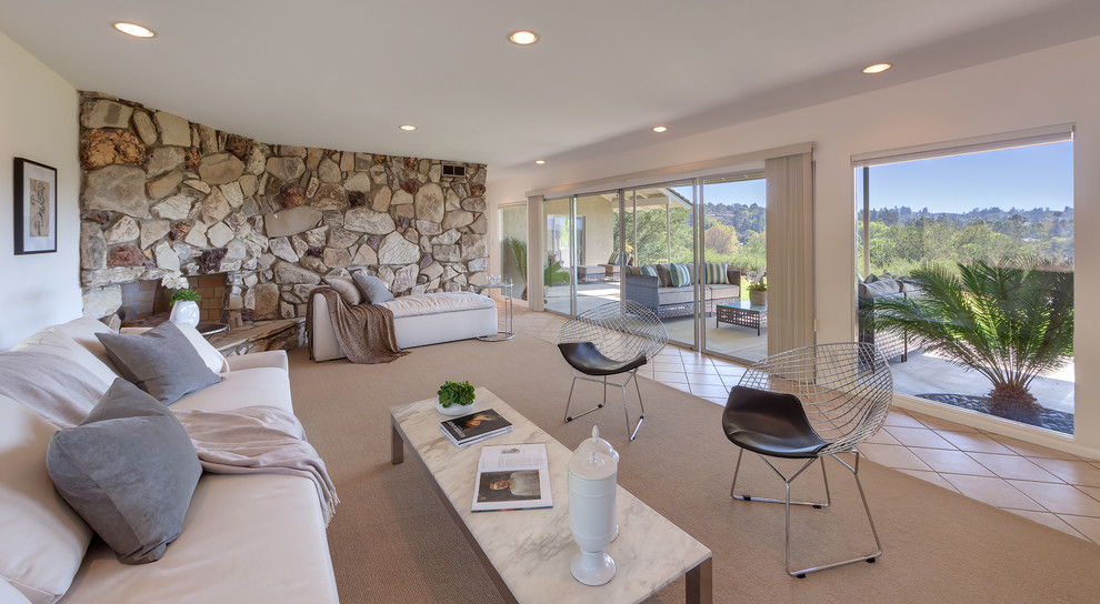 Идея дизайна: открытая гостиная комната среднего размера в стиле ретро с угловым камином, фасадом камина из камня и белыми стенами