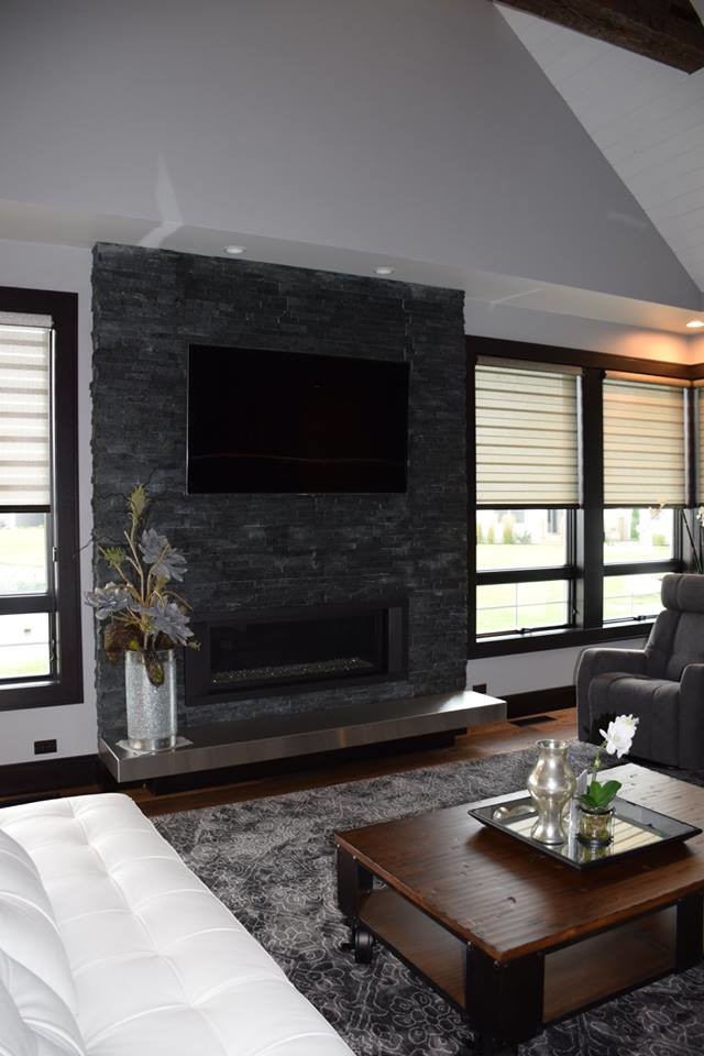 Стильный дизайн: гостиная комната среднего размера в стиле модернизм с серыми стенами, паркетным полом среднего тона, двусторонним камином, фасадом камина из кирпича и телевизором на стене - последний тренд