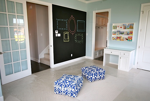 Foto på ett funkis vardagsrum, med ett bibliotek, blå väggar och heltäckningsmatta