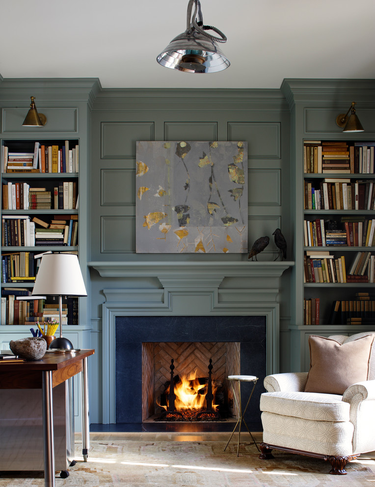 Пример оригинального дизайна: гостиная комната:: освещение в классическом стиле с с книжными шкафами и полками, стандартным камином, фасадом камина из камня и зелеными стенами