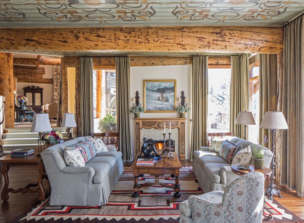 Diseño de salón para visitas tradicional con paredes blancas, suelo de madera en tonos medios, todas las chimeneas y cortinas