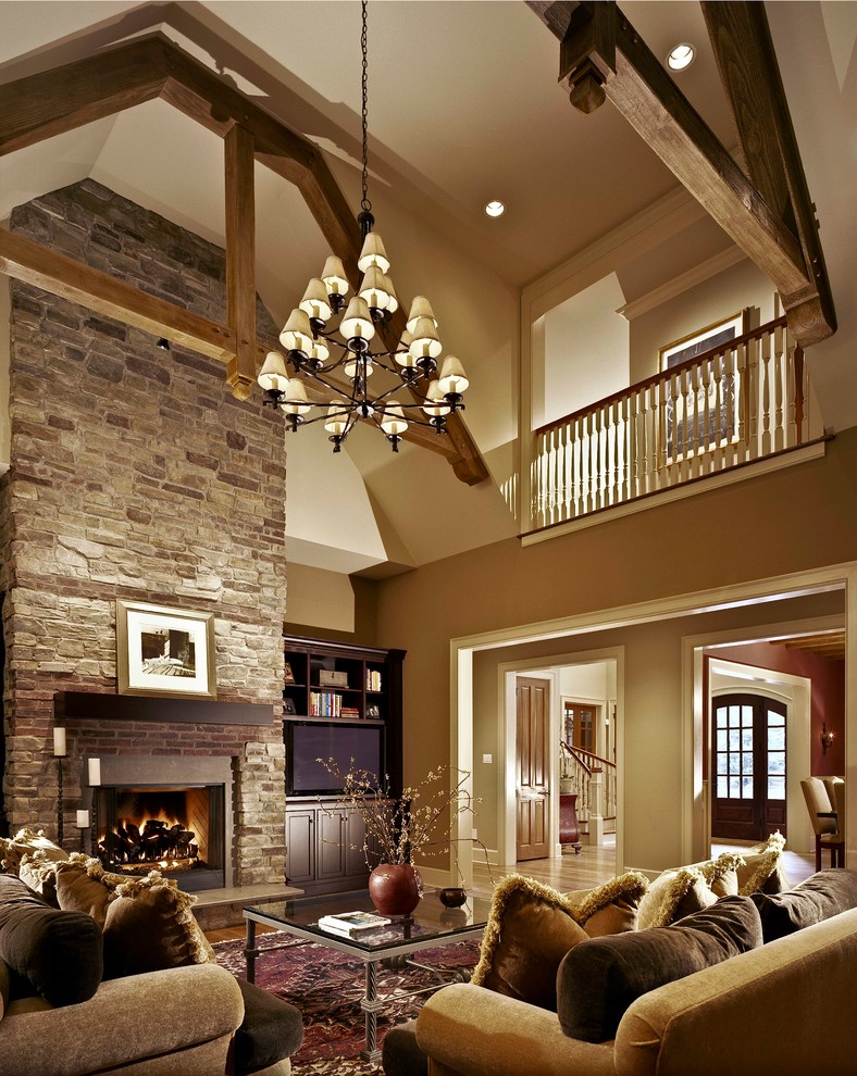 Example of a huge classic formal and open concept medium tone wood floor living room design in Charlotte with beige walls, a standard fireplace, a stone fireplace and no tv