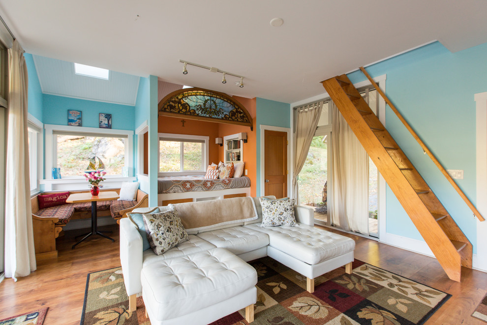 Esempio di un piccolo soggiorno nordico aperto con pareti blu, pavimento in legno massello medio e pavimento marrone