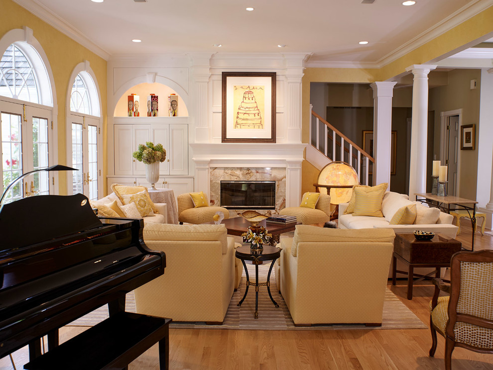Repräsentatives, Offenes Klassisches Wohnzimmer mit gelber Wandfarbe, braunem Holzboden, Kamin, Kaminumrandung aus Stein und gelbem Boden in Sonstige