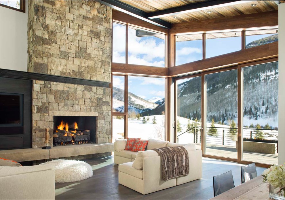 Example of a mountain style open concept dark wood floor living room design in Denver with white walls, a standard fireplace and a stone fireplace