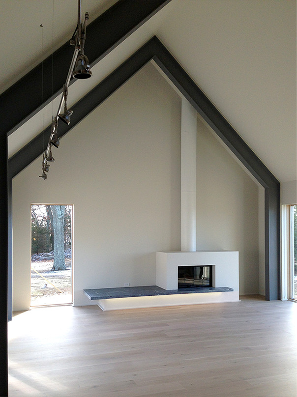 Inspiration pour un salon minimaliste ouvert avec un mur beige, parquet clair et cheminée suspendue.