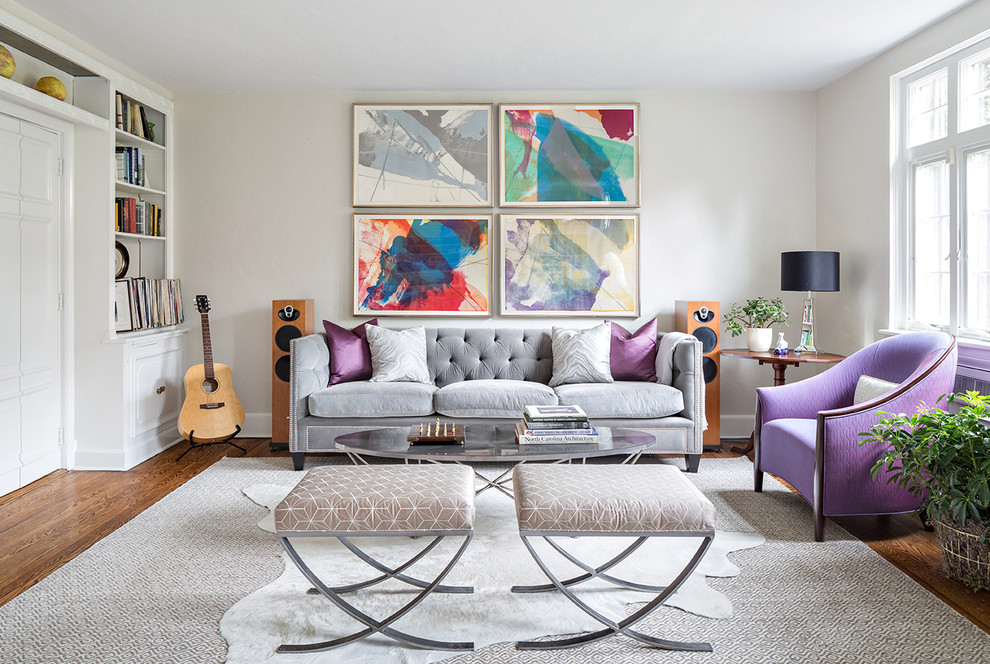 This is an example of a traditional formal and grey and purple living room in New York with white walls, medium hardwood flooring and feature lighting.