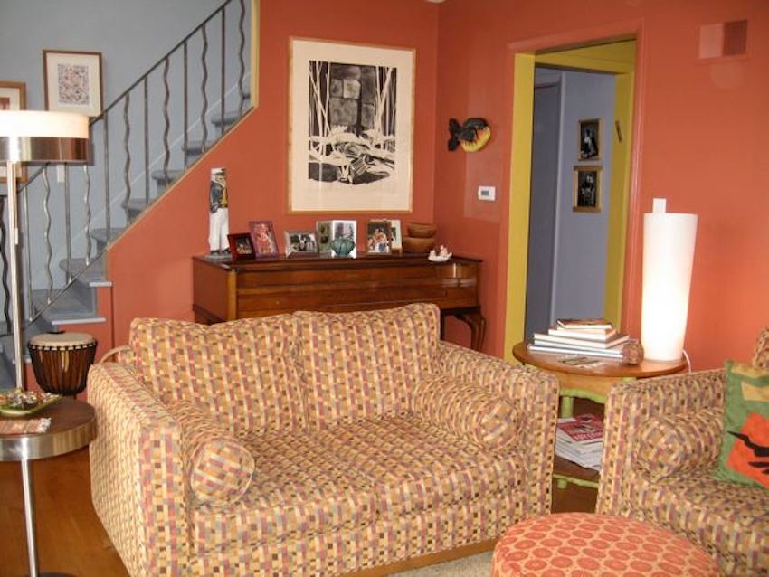 Modelo de salón para visitas cerrado ecléctico pequeño sin chimenea con pared multimedia, parades naranjas, suelo de madera en tonos medios y suelo marrón
