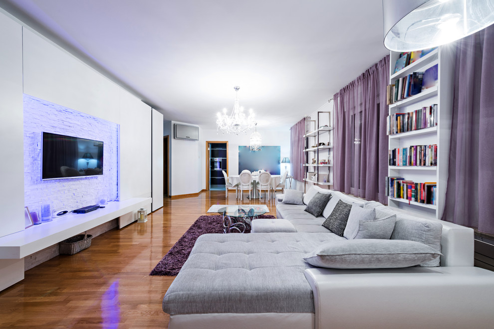 Exemple d'un salon mansardé ou avec mezzanine tendance de taille moyenne avec une bibliothèque ou un coin lecture, un mur blanc, parquet clair et un téléviseur encastré.