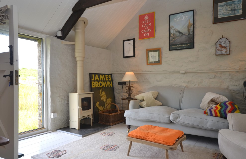 Imagen de salón para visitas cerrado clásico de tamaño medio con paredes blancas, suelo de madera clara y estufa de leña