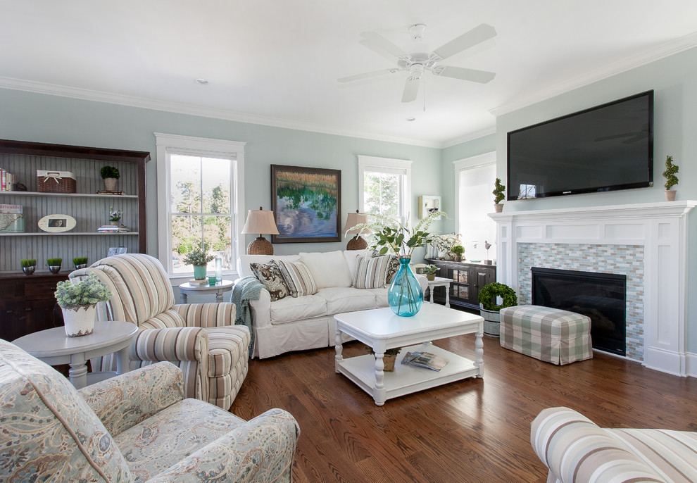 Coastal living room in Charleston with blue walls and a tiled fireplace surround.
