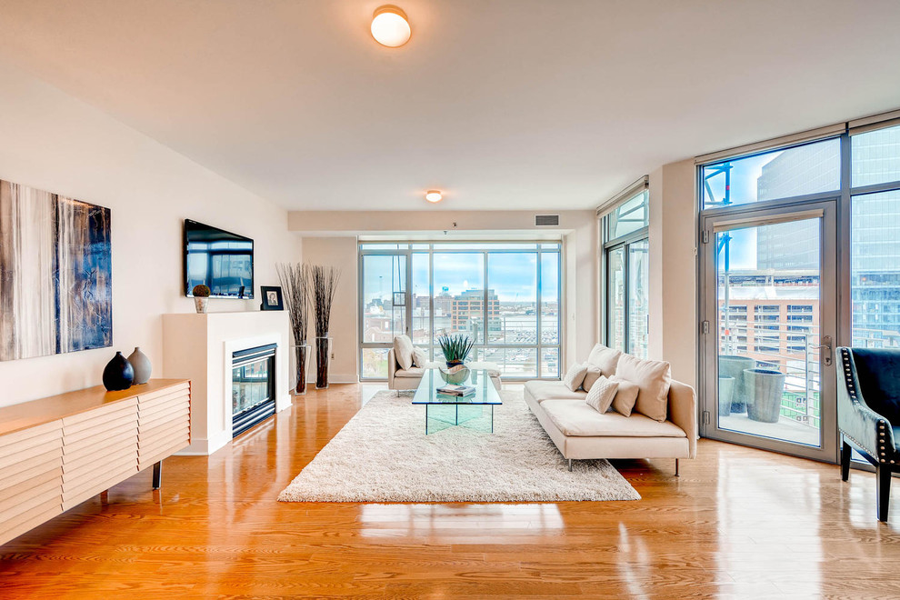 Immagine di un soggiorno design aperto con sala formale, pavimento in legno massello medio e camino classico