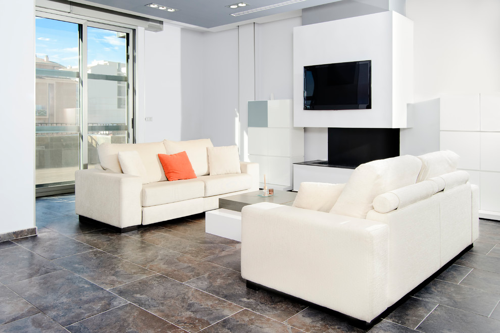 Diseño de salón actual con paredes blancas, televisor colgado en la pared y suelo gris