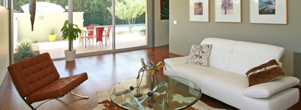 Mittelgroßes, Fernseherloses, Abgetrenntes Modernes Wohnzimmer ohne Kamin mit grauer Wandfarbe, braunem Holzboden und braunem Boden in Phoenix