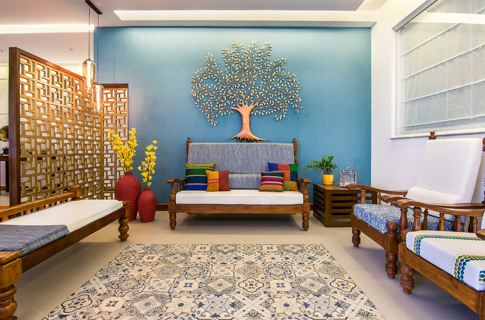 Réalisation d'un salon bohème de taille moyenne avec une salle de réception, un mur bleu et un sol gris.