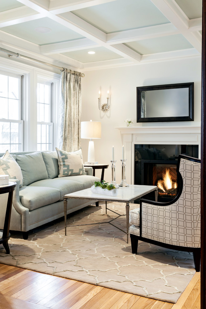 This is an example of a medium sized classic formal enclosed living room in Boston with white walls, medium hardwood flooring, a standard fireplace, no tv and a stone fireplace surround.