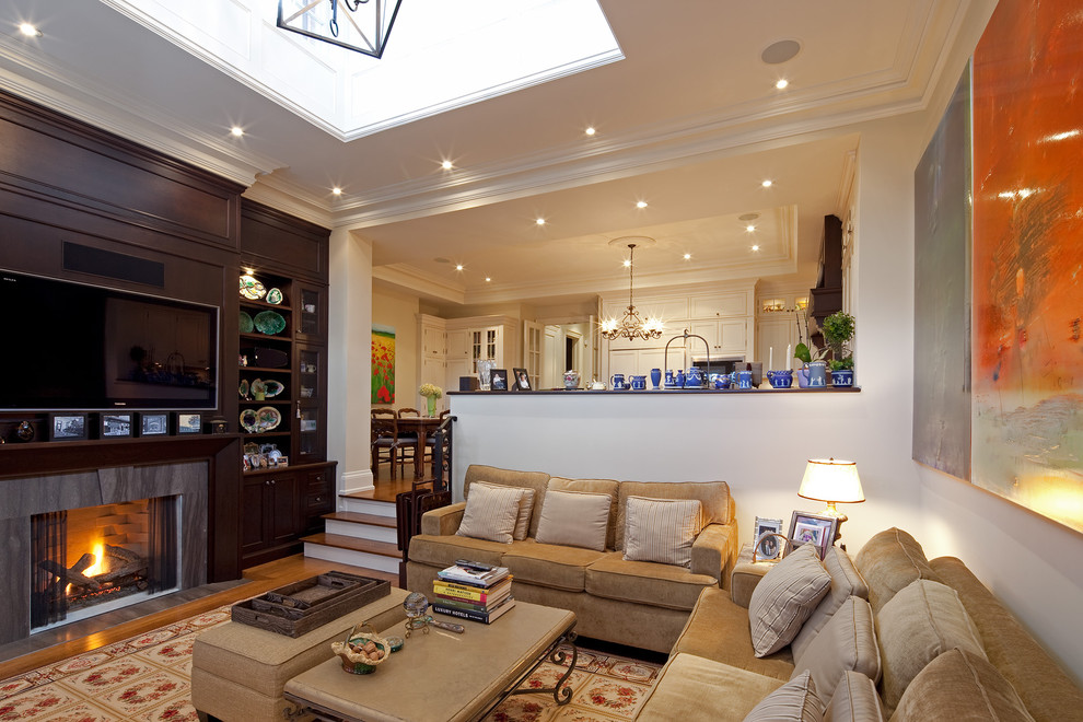 Стильный дизайн: гостиная комната в классическом стиле с стандартным камином и телевизором на стене - последний тренд
