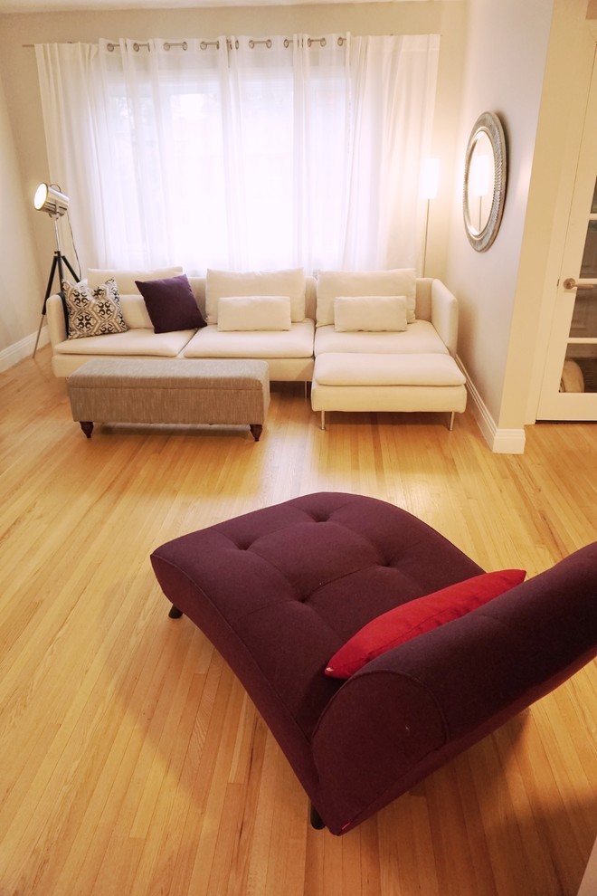 Diseño de salón abierto moderno de tamaño medio sin televisor con paredes grises y suelo de madera clara