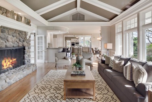 Living room with fireplace and couches, boasting a sleekly painted grey ceiling that enhances the cozy ambiance, showcasing the perfect choice of ceiling paint colour.