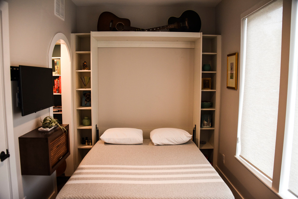 На фото: открытая гостиная комната среднего размера в стиле неоклассика (современная классика) с с книжными шкафами и полками, серыми стенами, темным паркетным полом, телевизором на стене и коричневым полом с