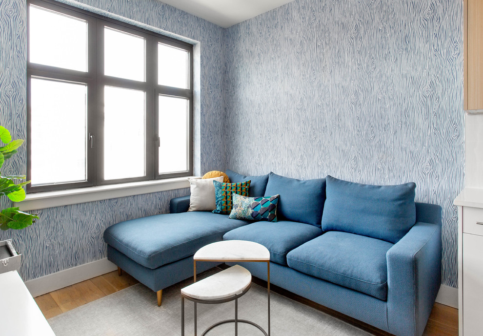 ニューヨークにある小さなコンテンポラリースタイルのおしゃれな独立型リビング (青い壁、淡色無垢フローリング、暖炉なし、据え置き型テレビ、ベージュの床) の写真