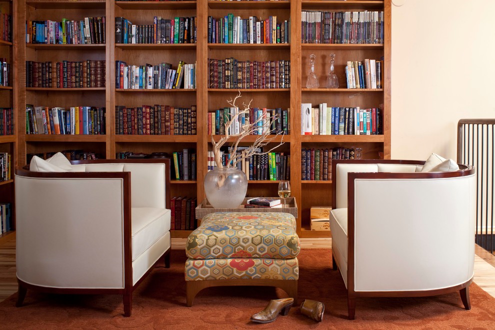 Imagen de biblioteca en casa tipo loft contemporánea de tamaño medio con paredes beige y suelo de madera clara