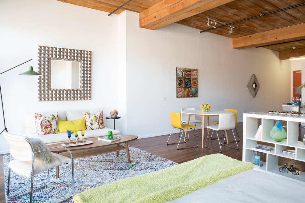 Imagen de salón para visitas industrial con paredes blancas y suelo de madera en tonos medios