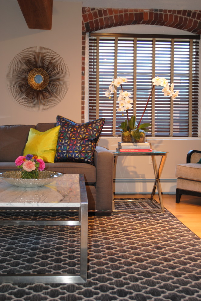 Immagine di un piccolo soggiorno bohémian stile loft con pareti beige, parquet chiaro e TV a parete