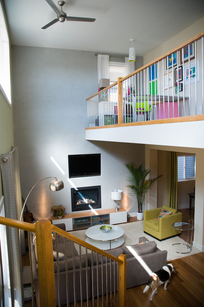 Пример оригинального дизайна: открытая гостиная комната среднего размера в современном стиле с желтыми стенами, полом из бамбука, подвесным камином, фасадом камина из штукатурки и мультимедийным центром