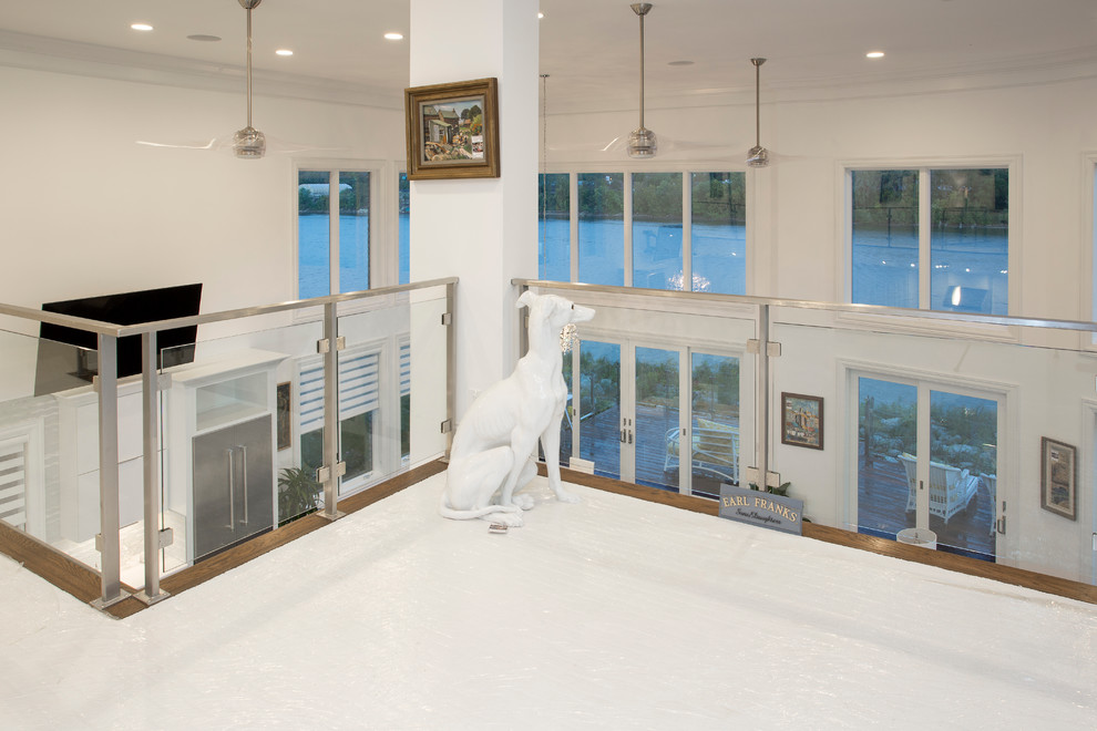 Ejemplo de salón abierto actual grande con paredes blancas, suelo de bambú y televisor colgado en la pared