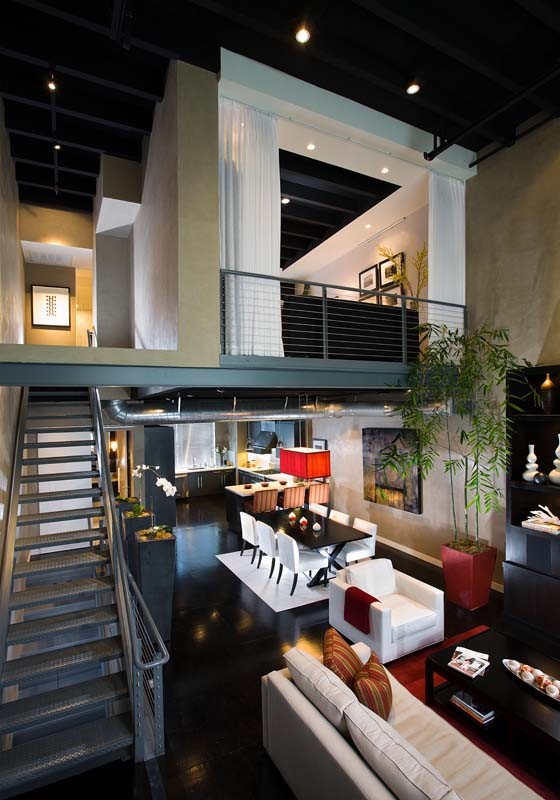 Huge minimalist loft-style black floor and plywood floor living room photo in Orange County with beige walls