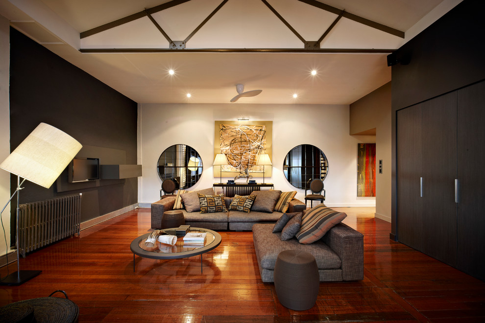 Esempio di un grande soggiorno minimal con pavimento in legno massello medio, pareti bianche, nessun camino e TV a parete