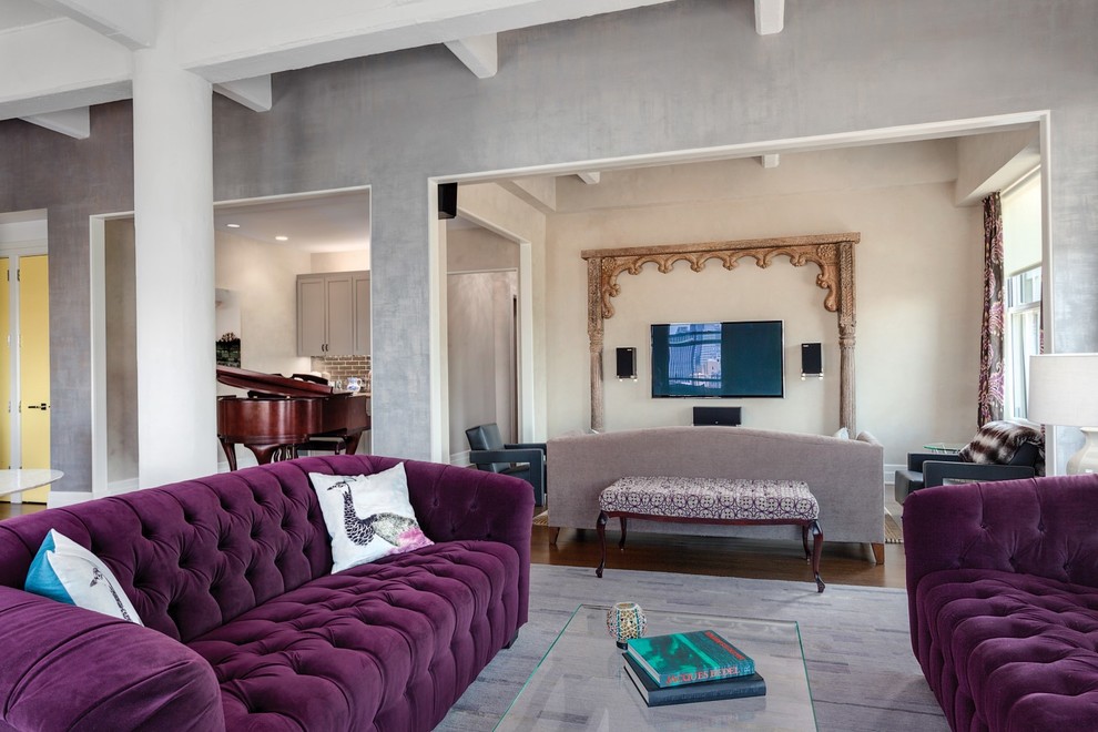 Foto de salón abierto bohemio grande con paredes grises, suelo de madera en tonos medios y televisor colgado en la pared