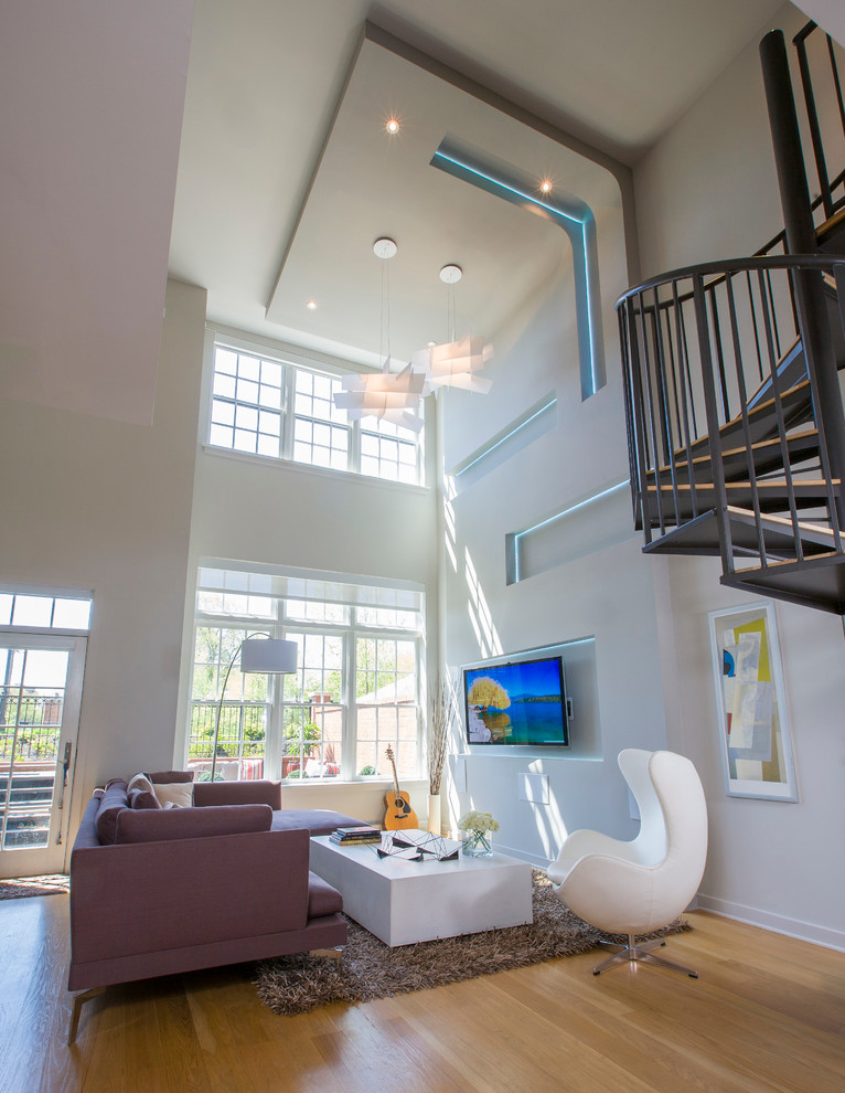 Foto di un grande soggiorno moderno stile loft con pareti bianche, pavimento in legno massello medio e TV a parete