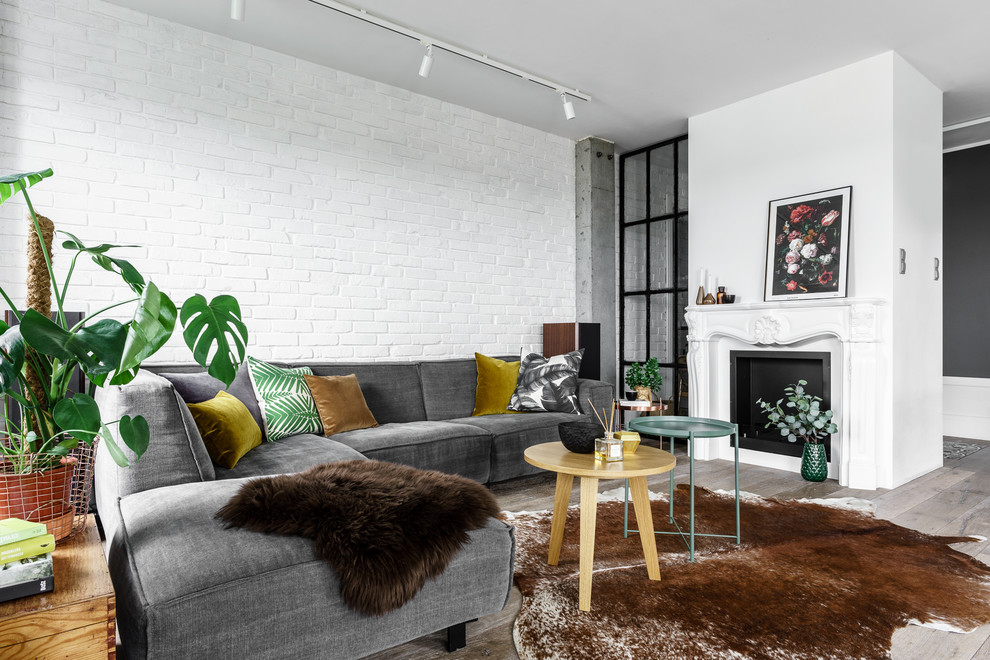 Fernseherloses Nordisches Wohnzimmer mit weißer Wandfarbe, hellem Holzboden, Kamin und Kaminumrandung aus Metall in Sonstige