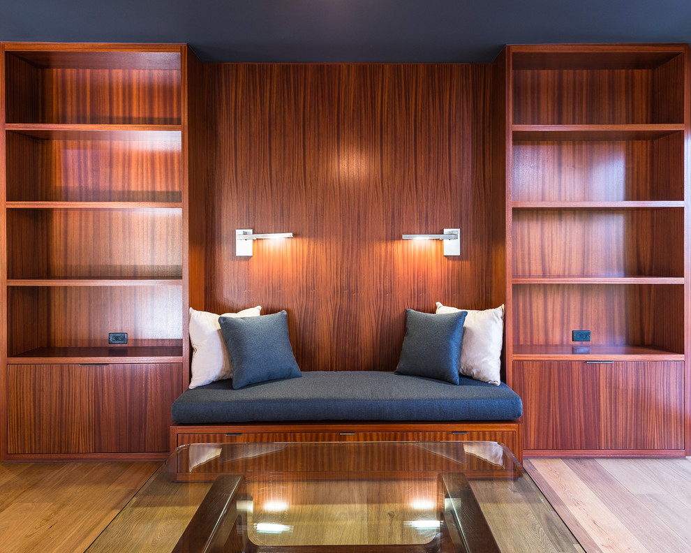 Idee per un grande soggiorno minimalista stile loft con libreria, pareti marroni, parquet chiaro e nessuna TV