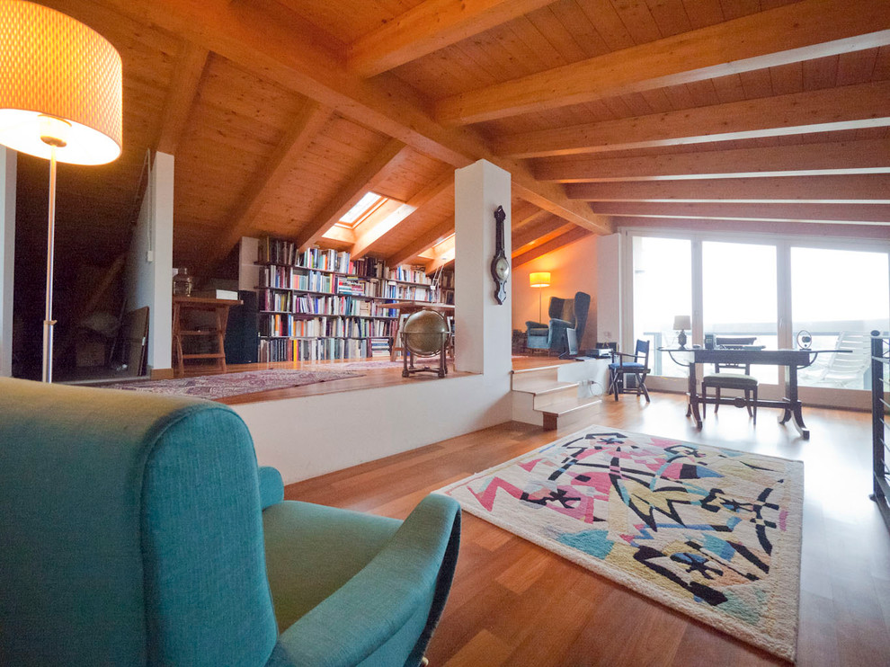 Imagen de biblioteca en casa tipo loft rústica grande sin televisor con paredes blancas y suelo de madera en tonos medios