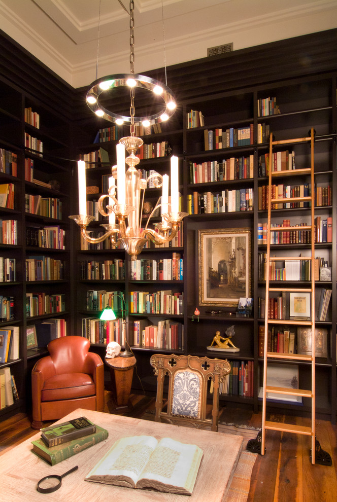 Inspiration för ett vintage vardagsrum, med ett bibliotek, svarta väggar och mellanmörkt trägolv