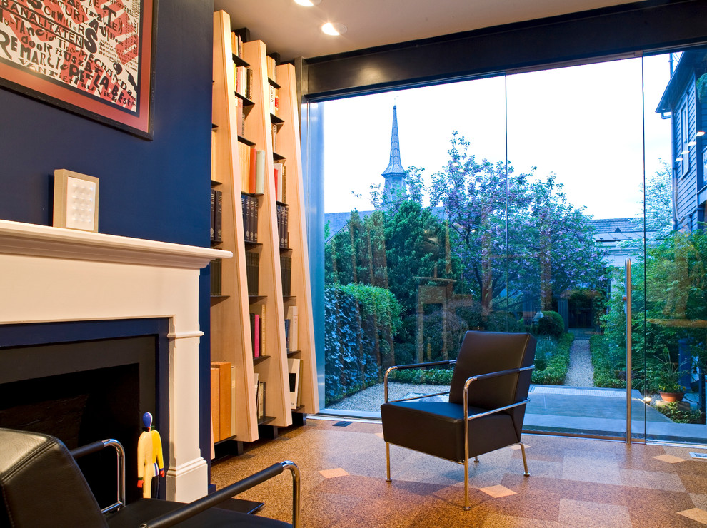 Foto di un soggiorno minimal di medie dimensioni con pavimento in sughero, pareti blu, camino classico, cornice del camino in legno e sala formale