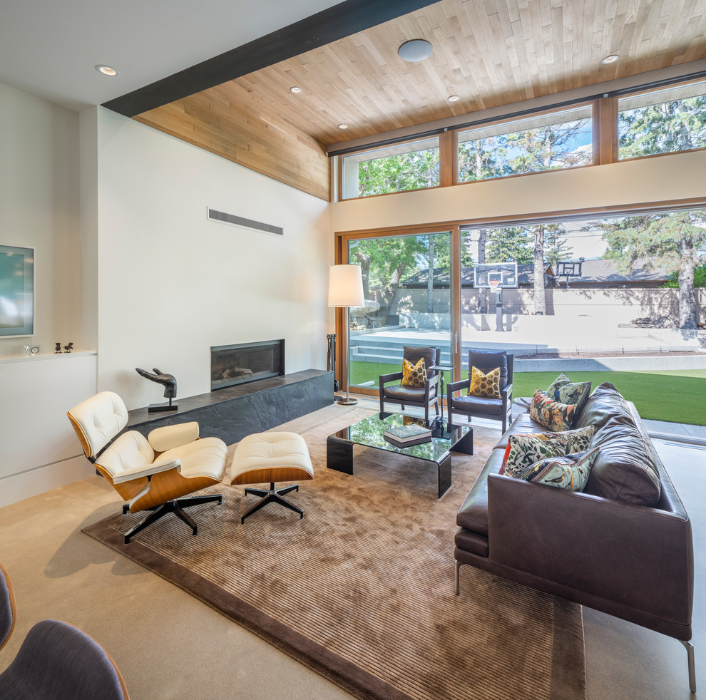 Offenes Retro Wohnzimmer mit weißer Wandfarbe, Betonboden, Gaskamin und grauem Boden in Calgary