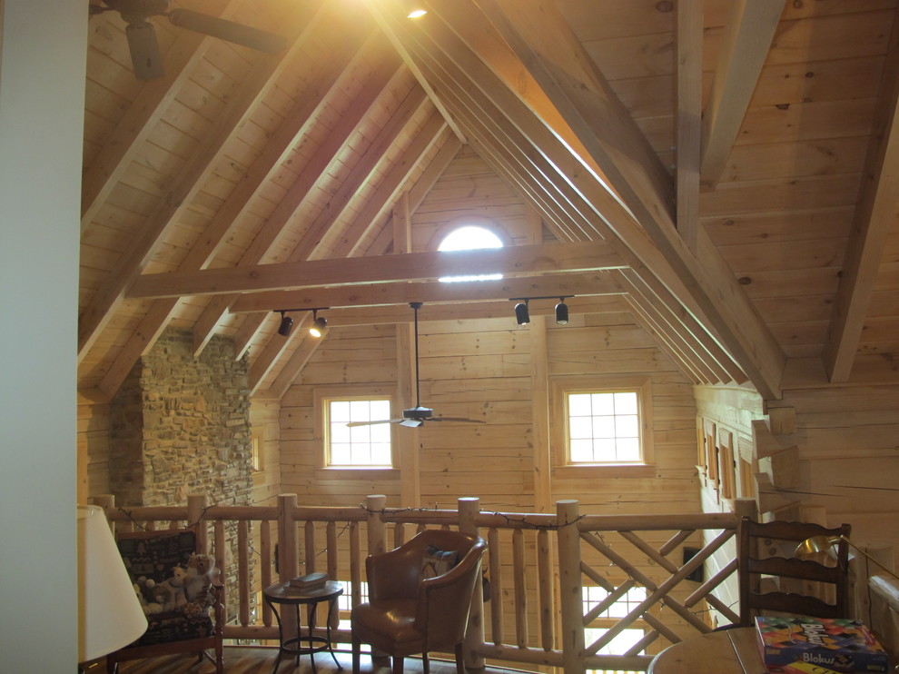 Foto de biblioteca en casa tipo loft rural de tamaño medio sin chimenea y televisor con paredes marrones y suelo de madera clara