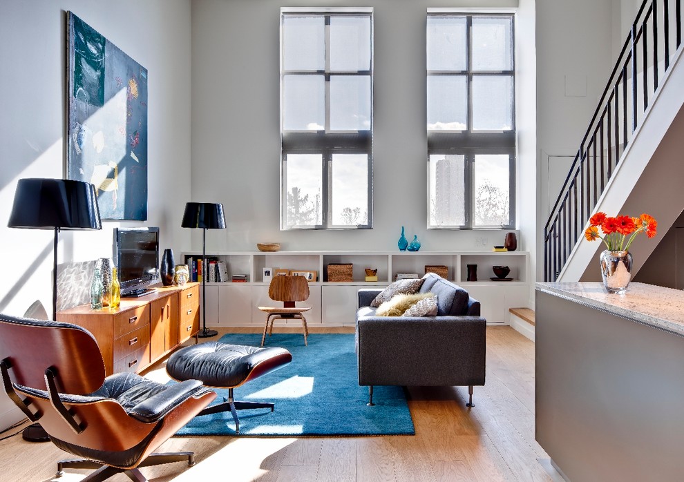 Esempio di un soggiorno moderno aperto e di medie dimensioni con pareti bianche, parquet chiaro e TV autoportante