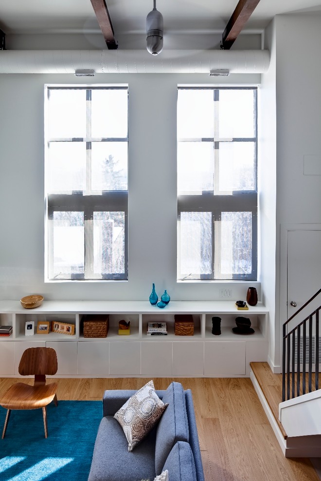Immagine di un soggiorno minimalista di medie dimensioni e aperto con pareti bianche, parquet chiaro e TV autoportante