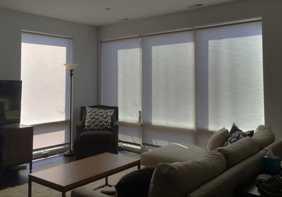 Immagine di un grande soggiorno minimalista aperto con pareti grigie, parquet scuro e TV autoportante