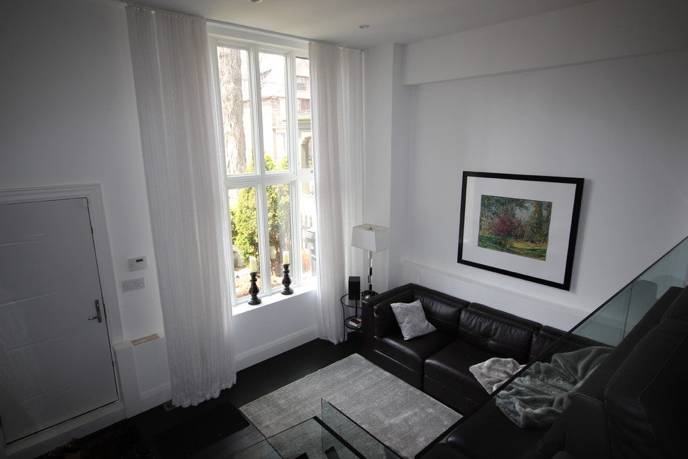 Immagine di un soggiorno minimal di medie dimensioni e aperto con sala formale, pareti bianche e parquet scuro