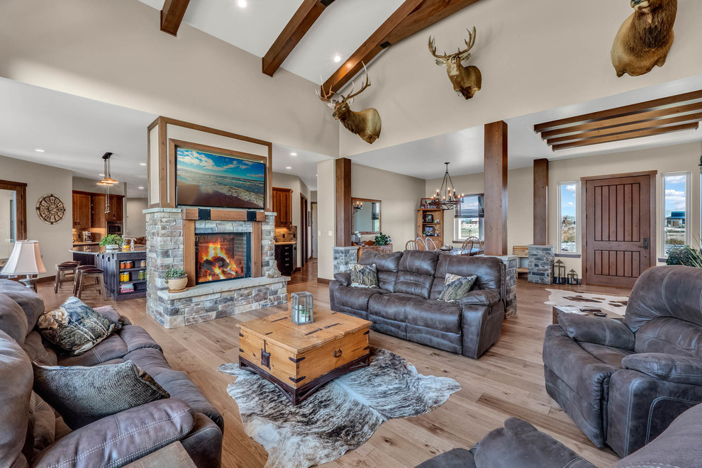 Medium sized traditional open plan living room in Denver with beige walls, medium hardwood flooring, a two-sided fireplace, a stone fireplace surround and multi-coloured floors.