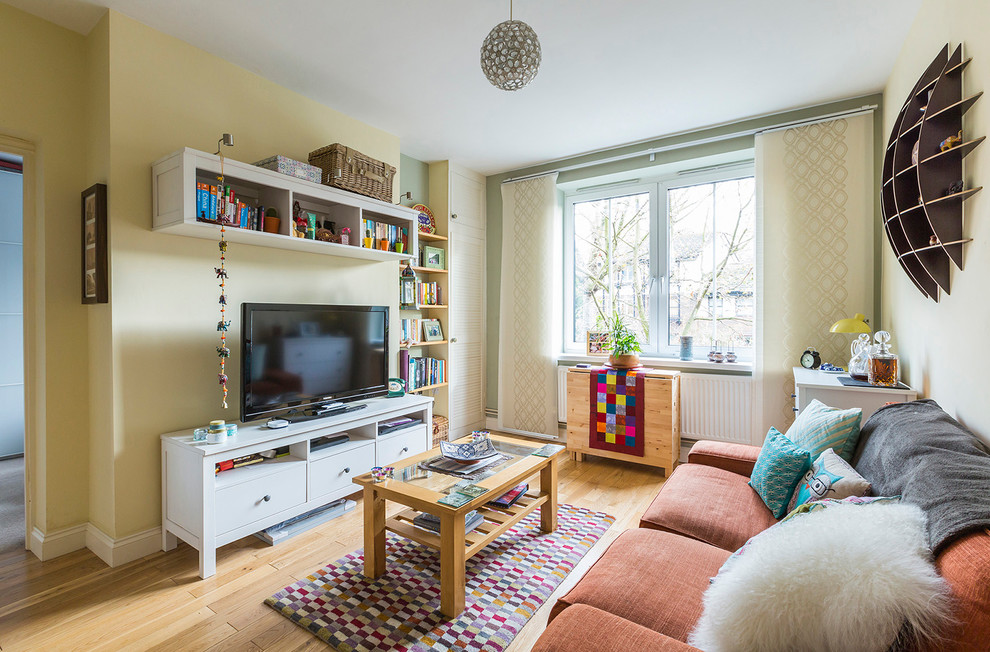Diseño de salón cerrado actual de tamaño medio con televisor independiente, paredes multicolor y suelo de madera clara