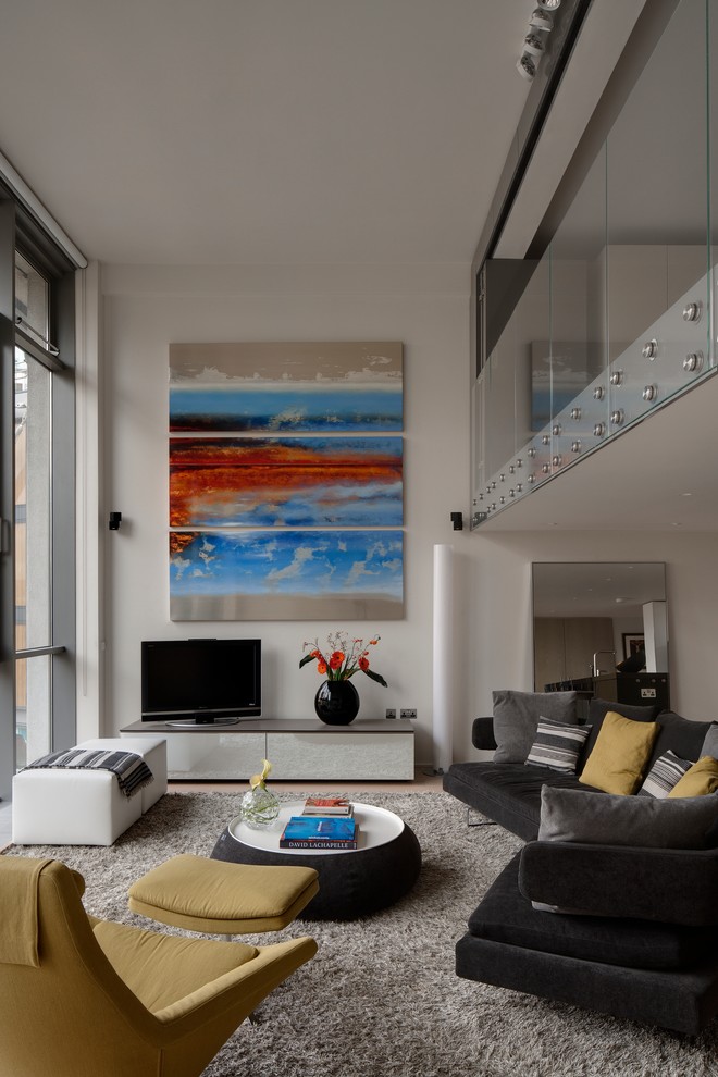 Cette image montre un salon design avec un mur blanc et un téléviseur indépendant.